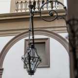 Dai muri pendono stupendi lampadari in ferro battuto decorato con foglie e fiori...